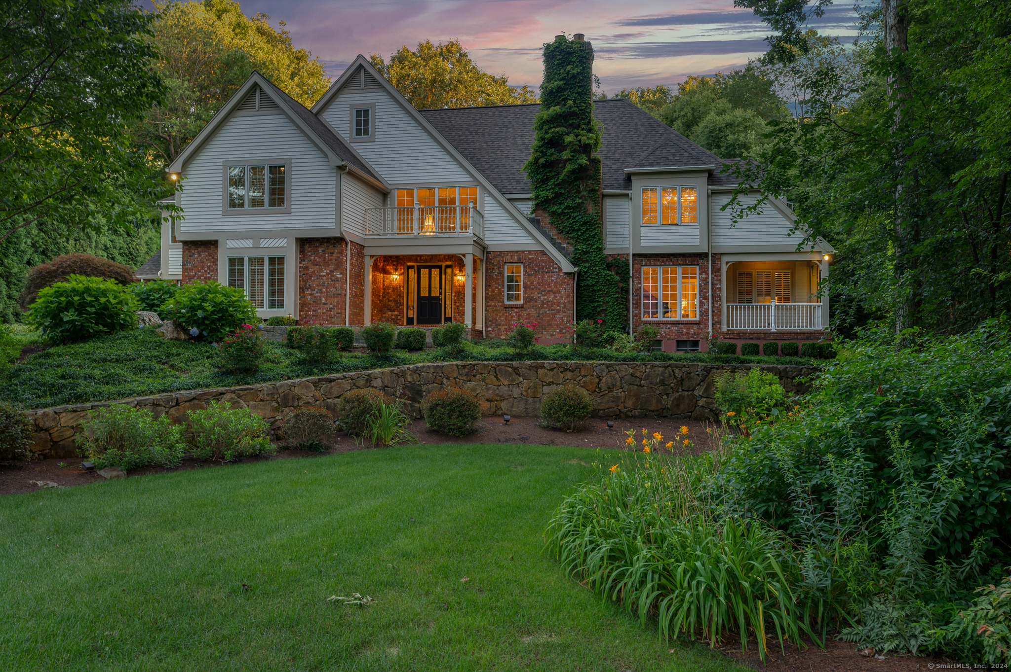 a front view of a house with a yard and potted plants