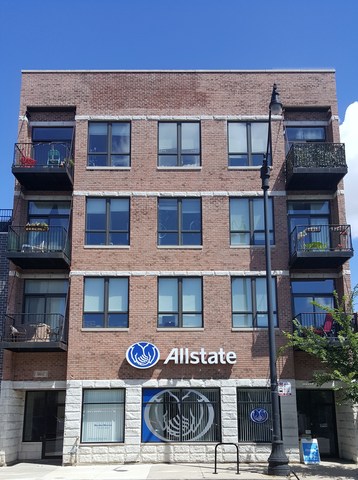 a front view of a building with glass windows and a street