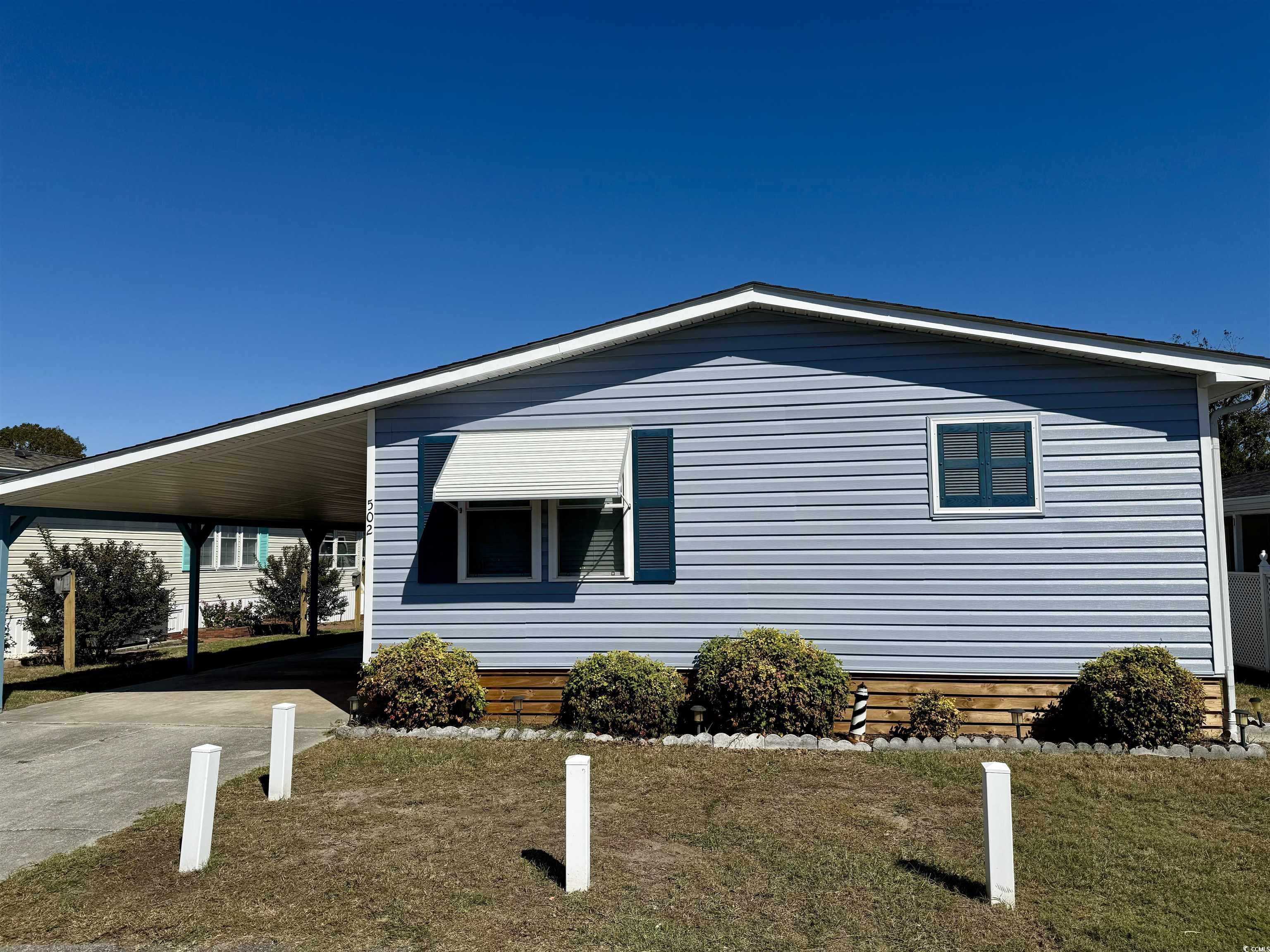 View of home's exterior featuring a lawn and a car