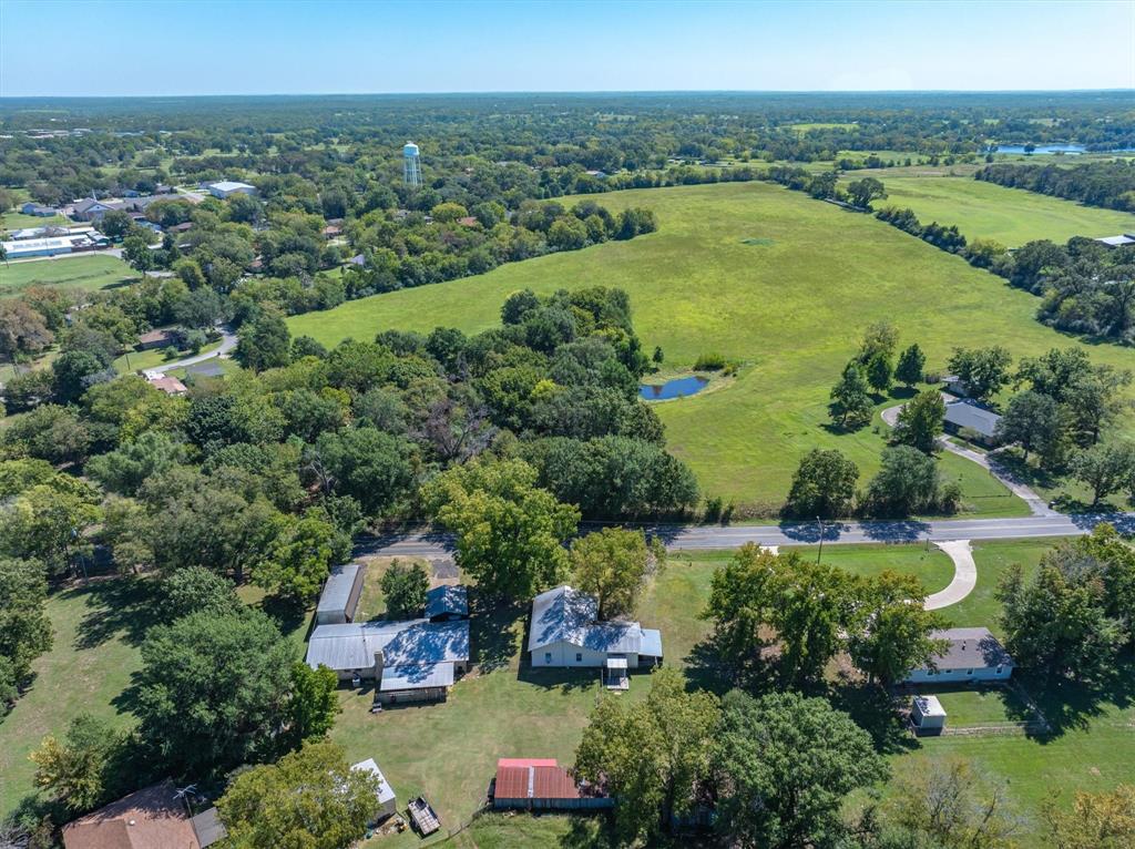 an aerial view of green landscape with trees houses and lake view