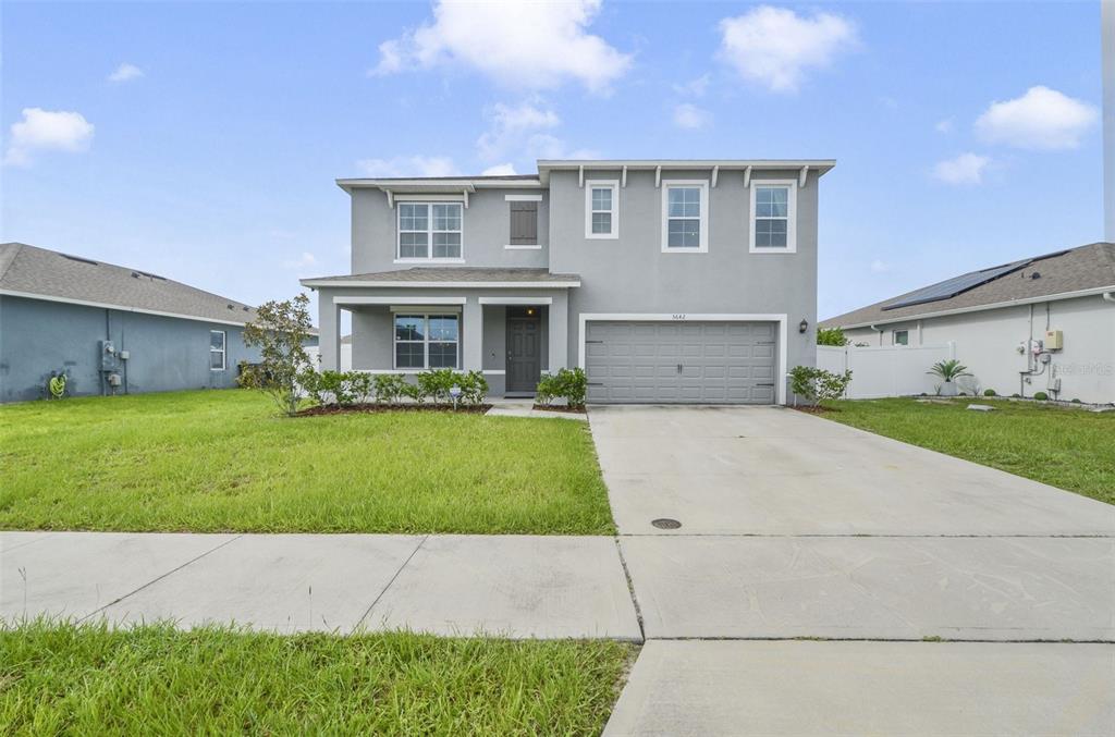 a front view of a house with a yard and garage