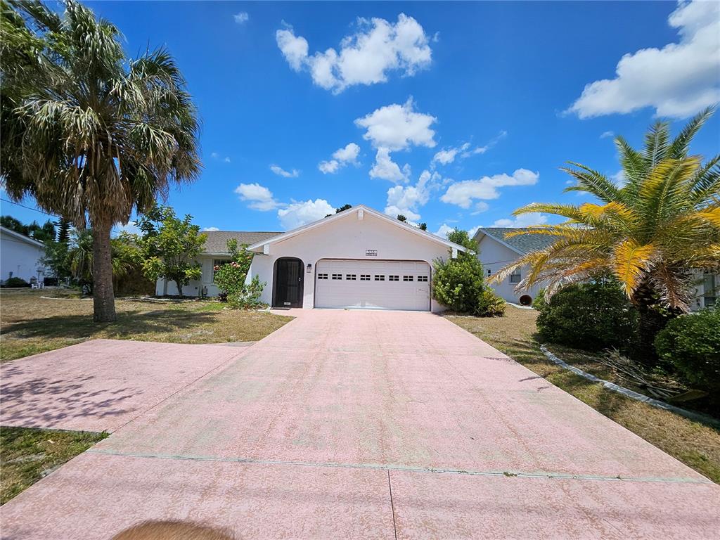 a view of a house with a yard and a large tree