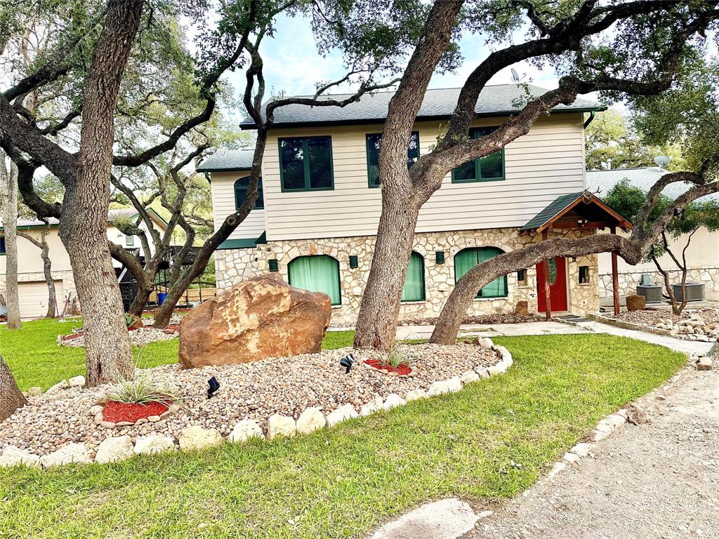 a view of a white house with a large tree