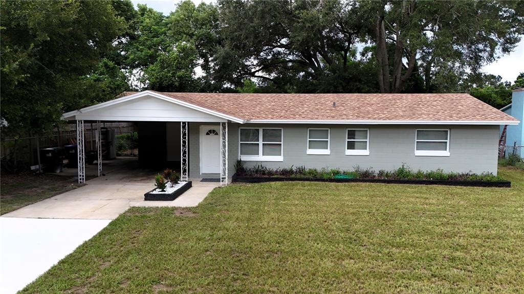 a front view of a house with a garden and trees