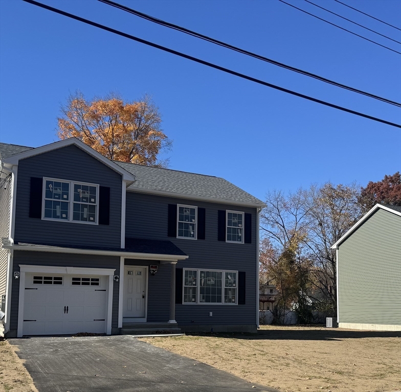 a front view of a house with a tree