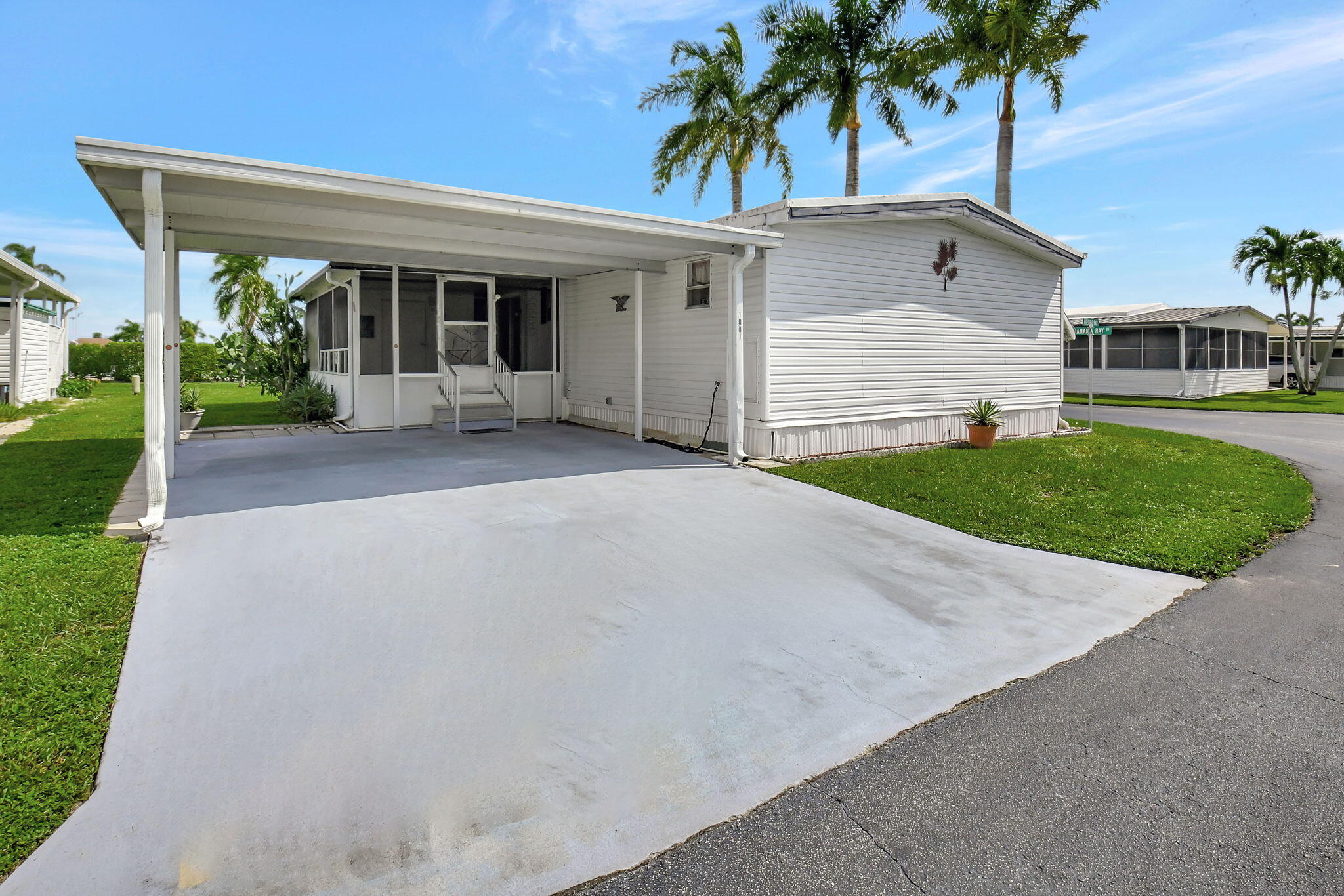 front view of a house with a yard and palm trees