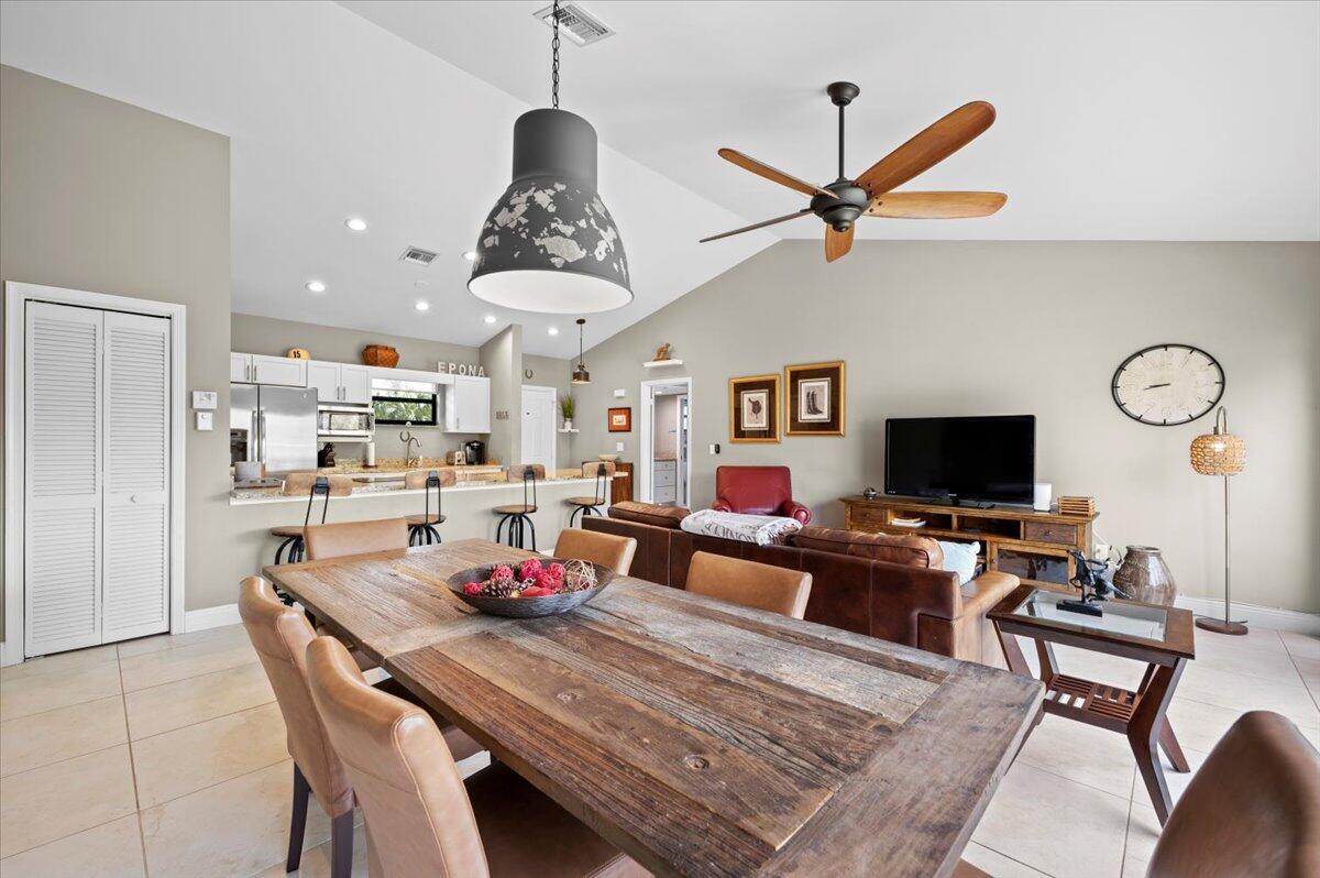 a living room with stainless steel appliances furniture a rug and a flat screen tv