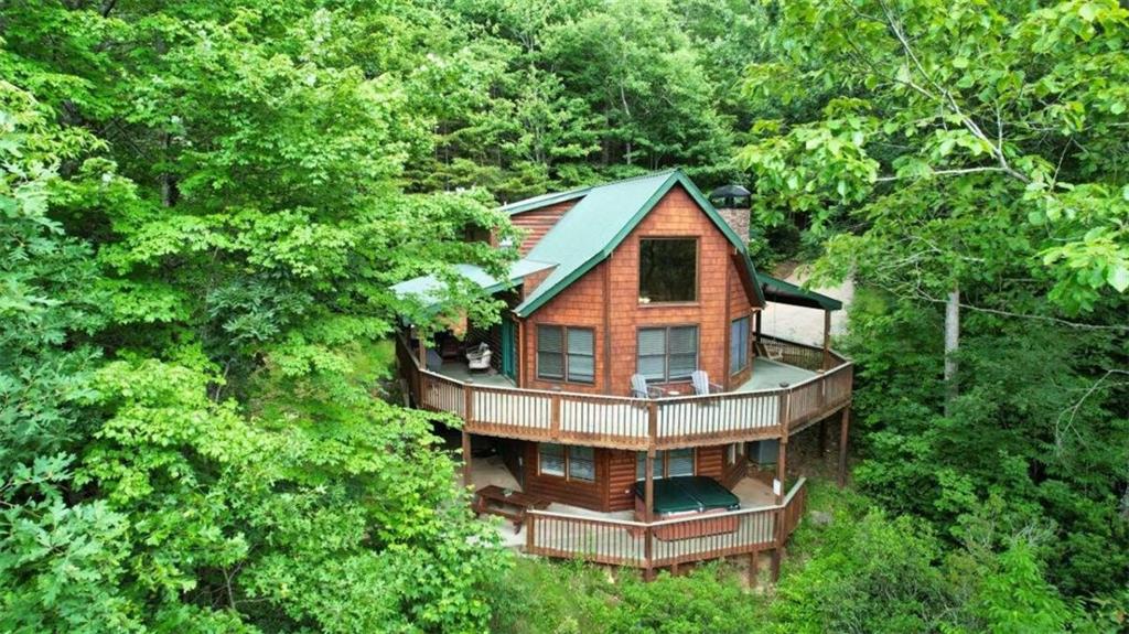 a view of house with a yard and large trees