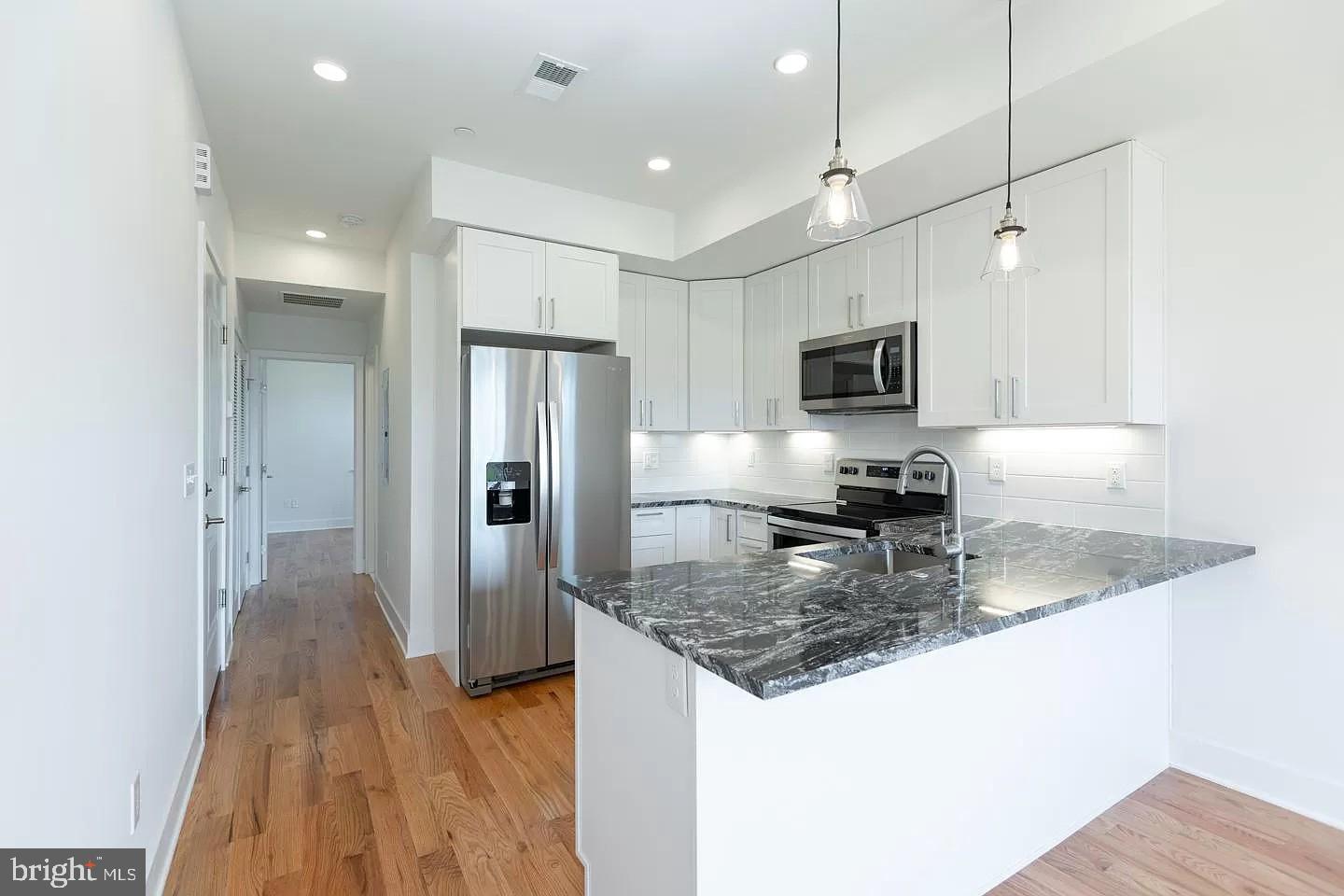 a kitchen with a refrigerator a sink and a microwave