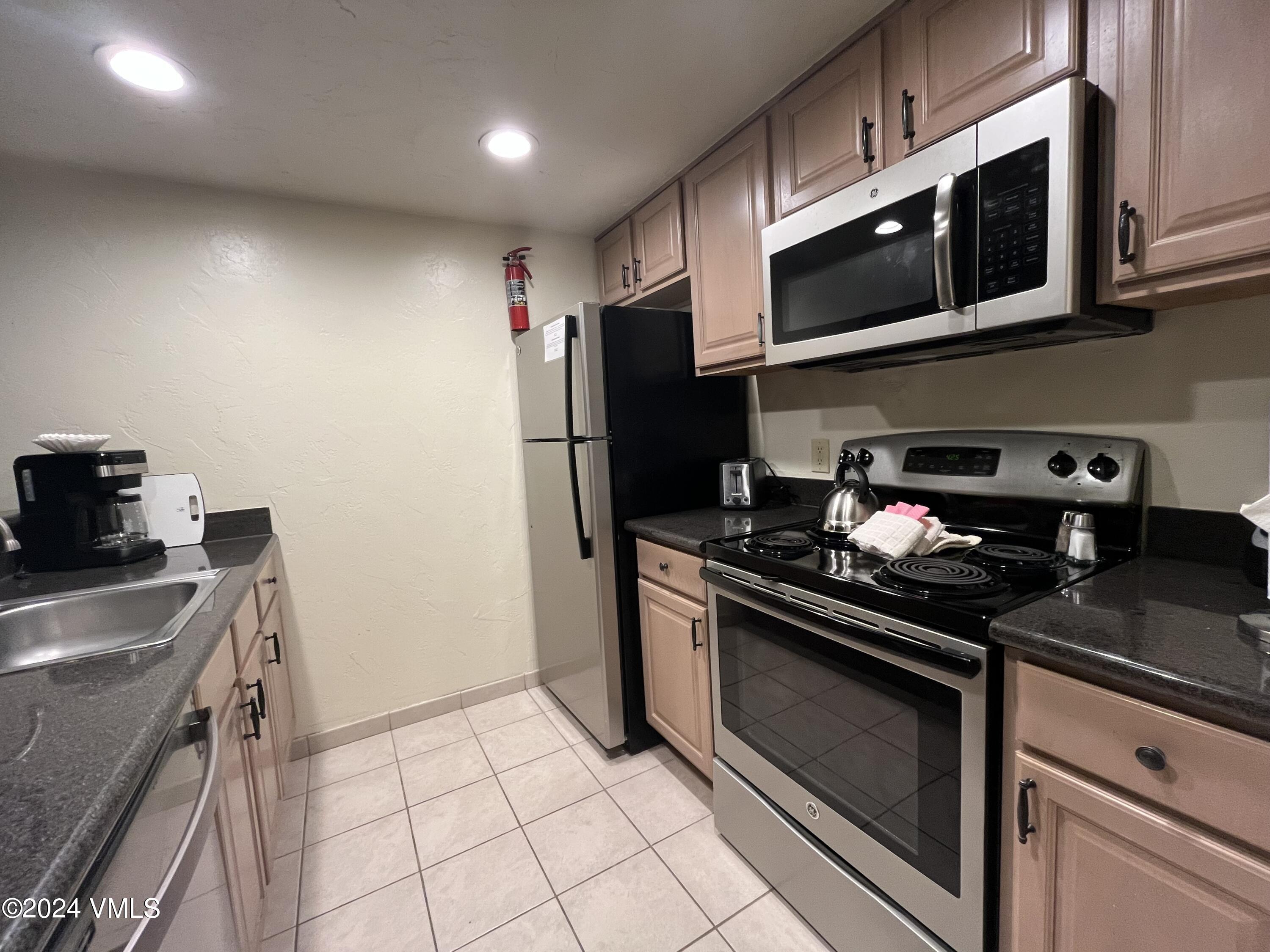 a kitchen with stainless steel appliances granite countertop a stove and a microwave