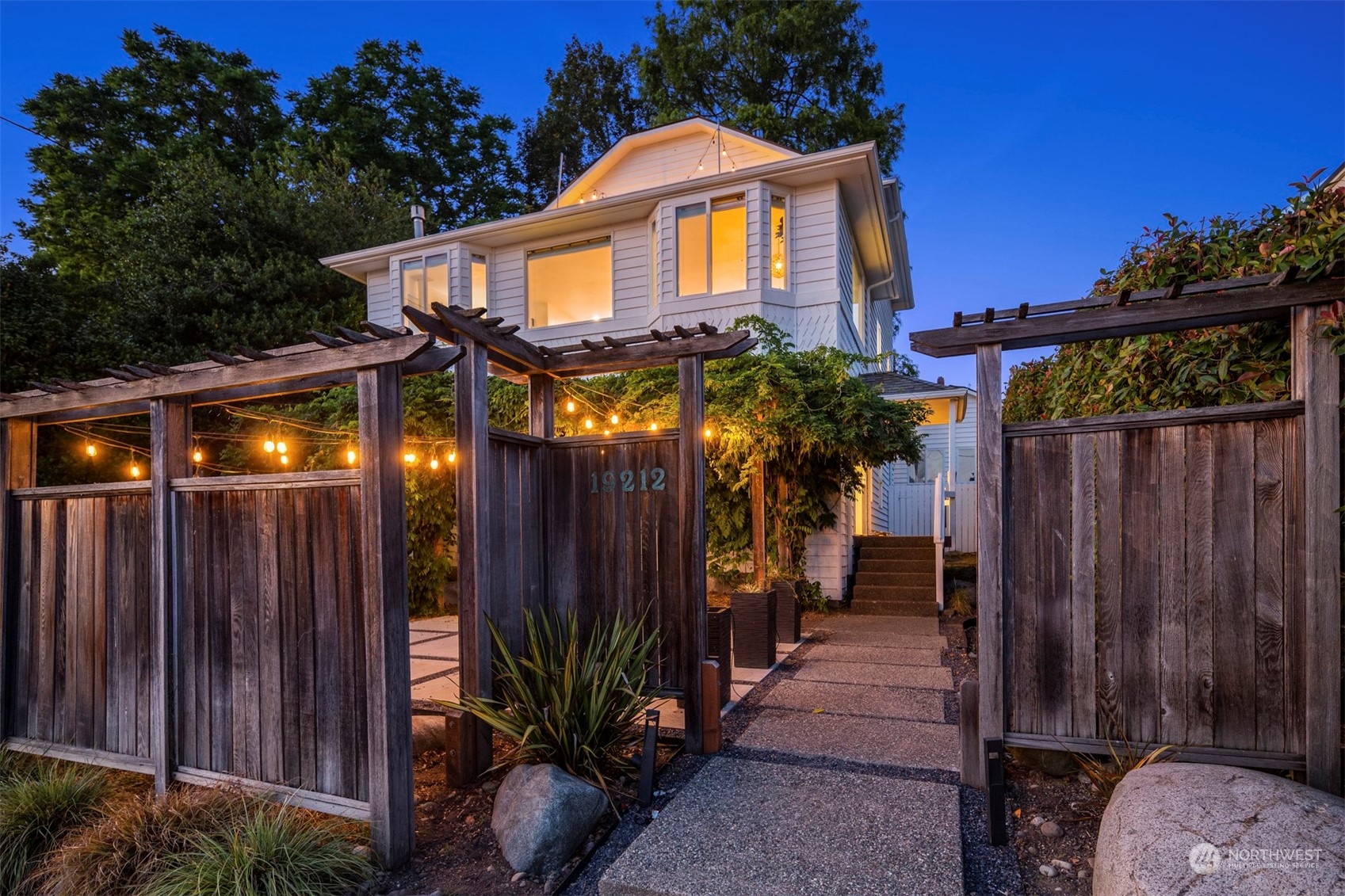 a view of a house with a potted plants and wooden fence