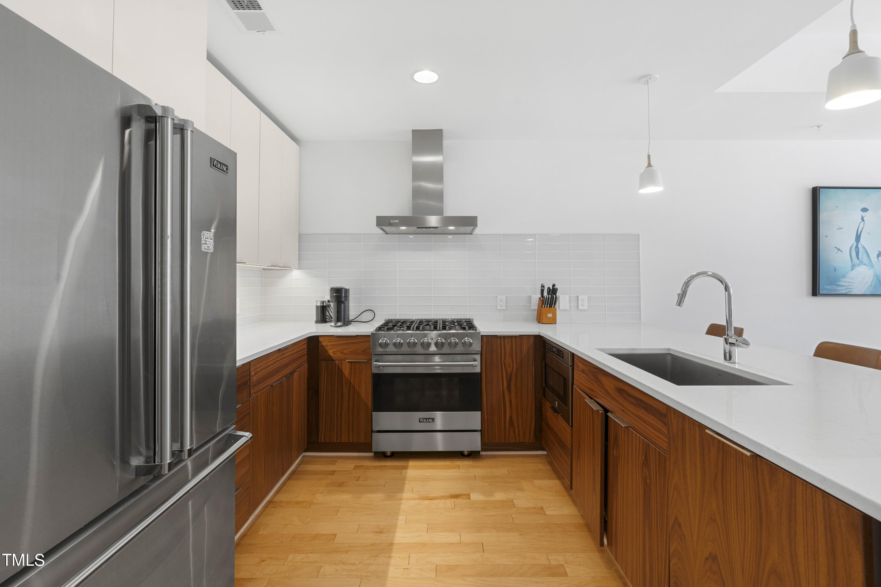 a kitchen with stainless steel appliances a sink stove and refrigerator