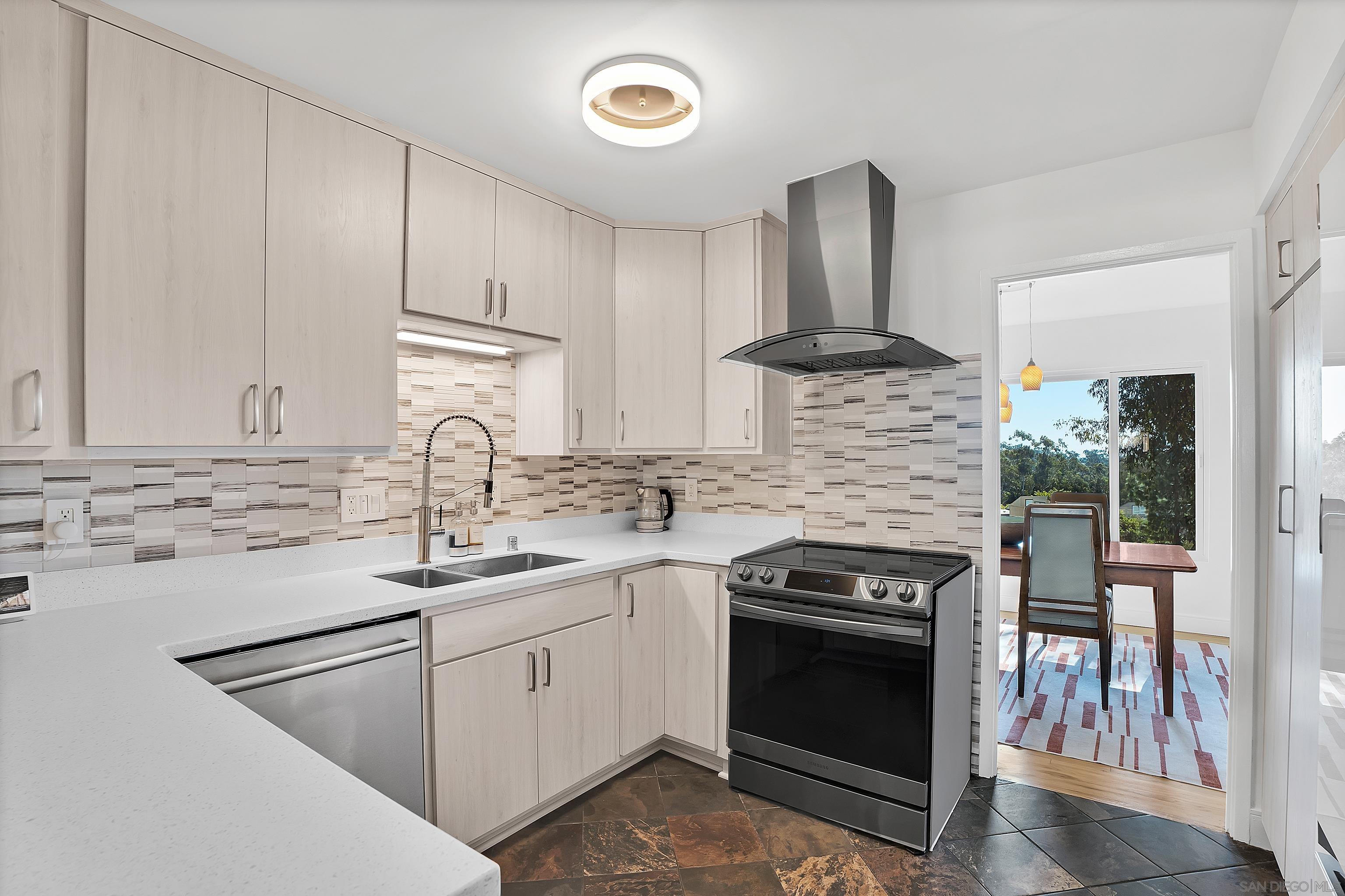 a kitchen with stainless steel appliances granite countertop a stove sink and cabinets