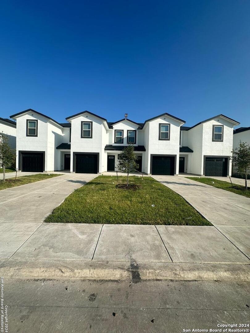 a front view of residential houses with yard