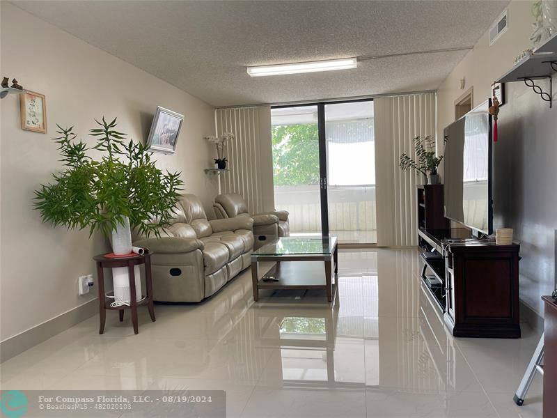 a living room with furniture bookshelf and a flat screen tv