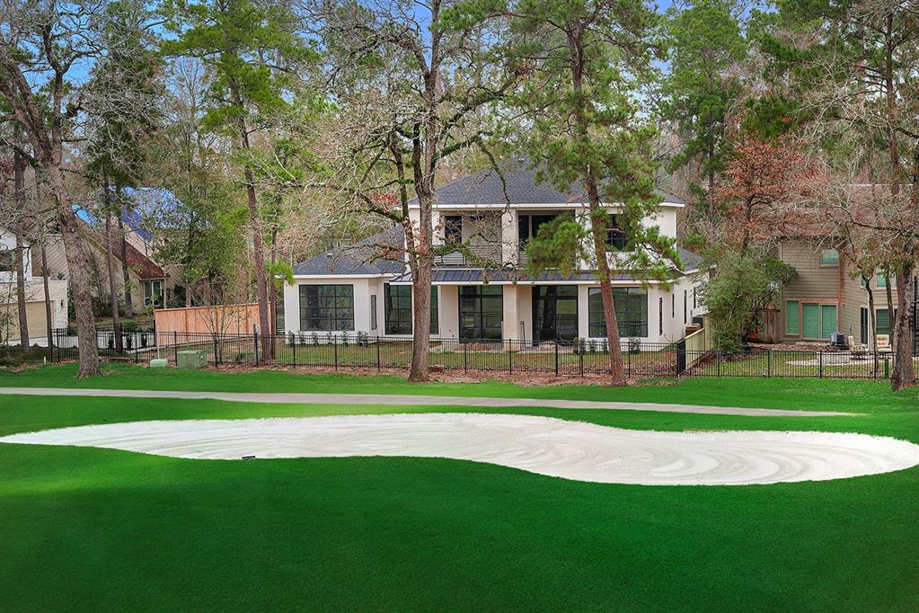 a front view of a house with a garden and trees