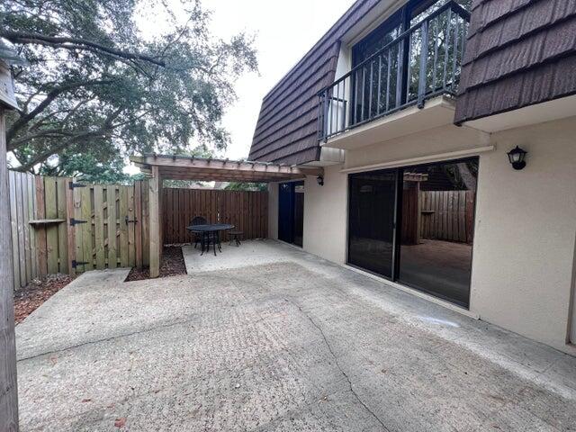 a view of backyard with seating space and wooden fence