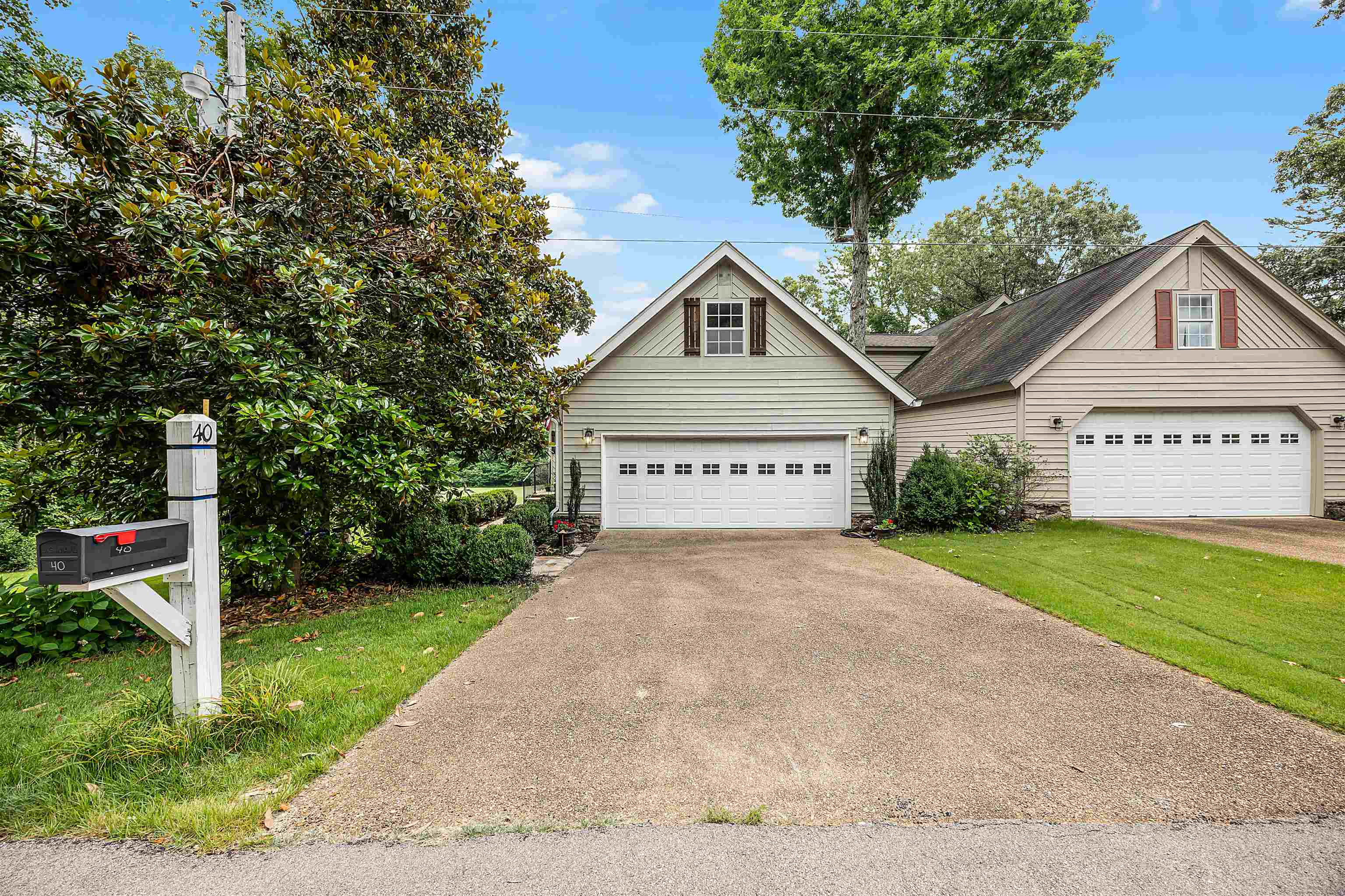 a view of a house with a yard and a large tree