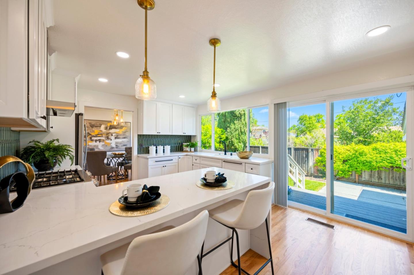 a kitchen with a sink a counter top space and living room view