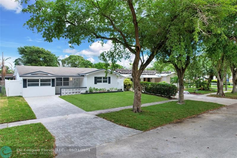 a front view of a house with a yard and trees