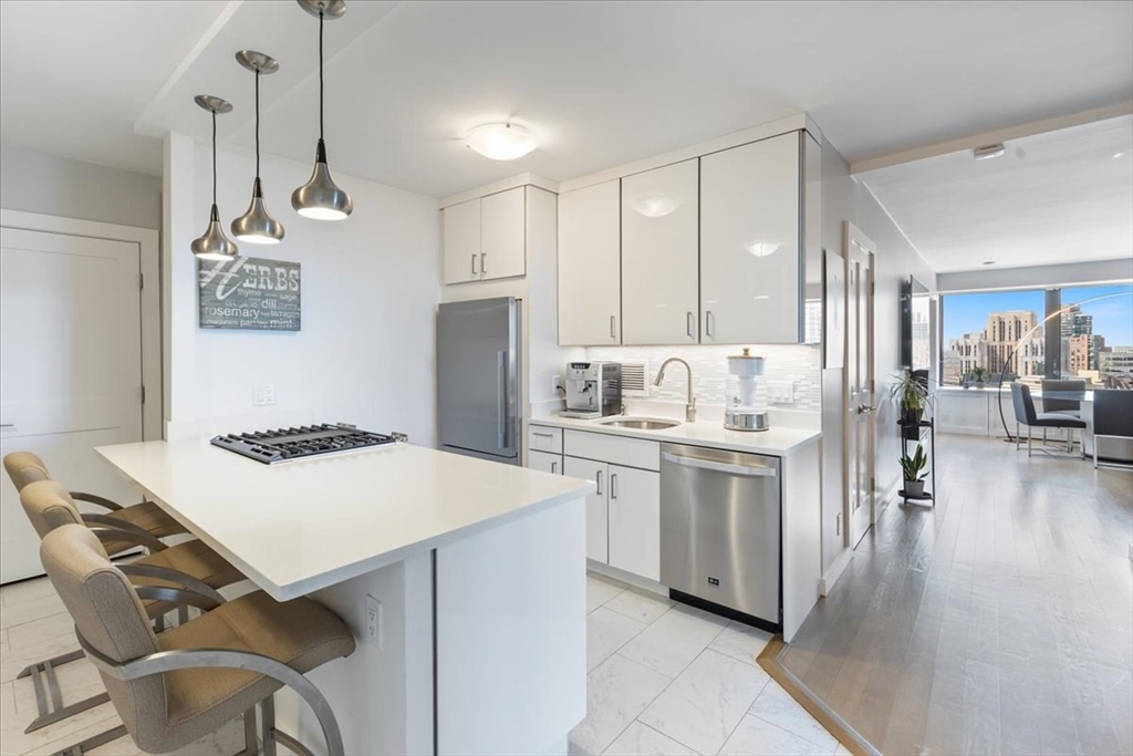 a kitchen that has a lot of cabinets in it and wooden floors