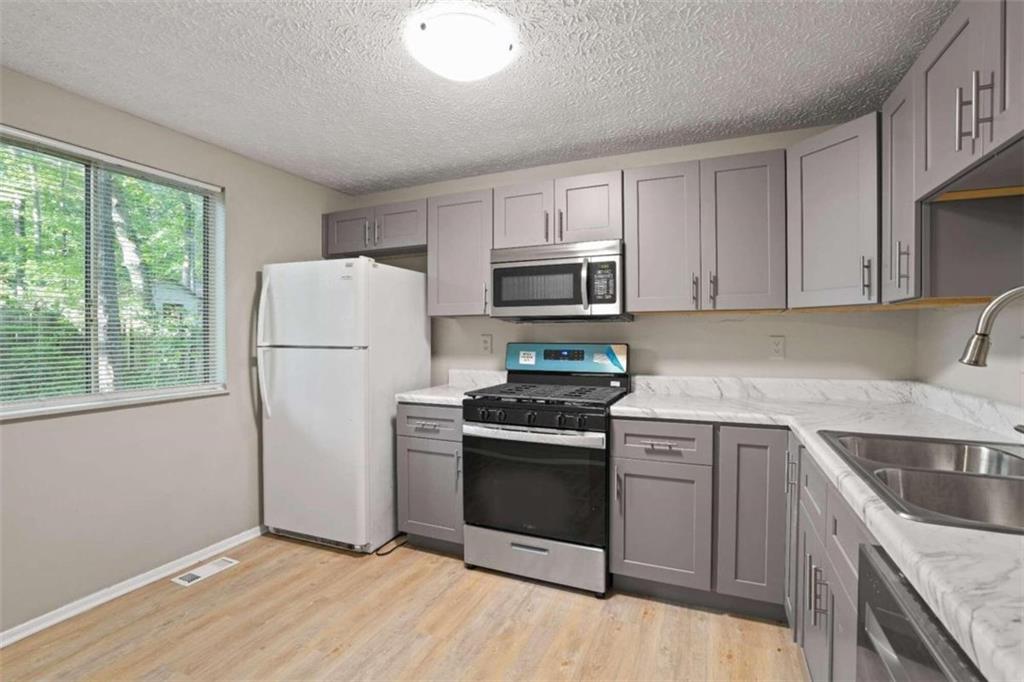 a kitchen with a stove a sink and a refrigerator