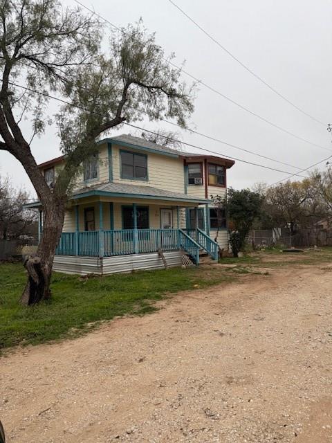 a view of a house with a yard and large tree