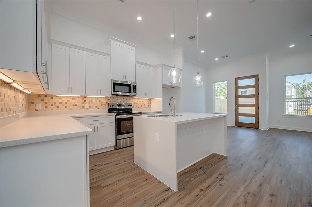 a kitchen with a refrigerator and a stove top oven