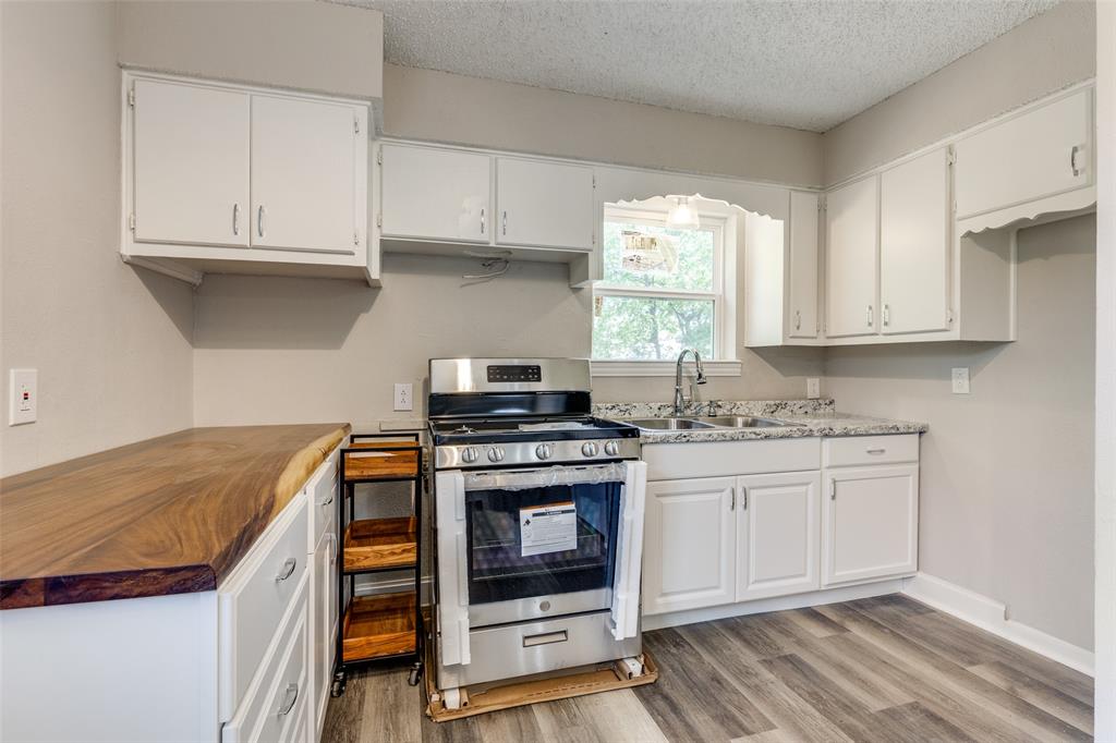 a kitchen with stainless steel appliances granite countertop a stove and a white cabinets