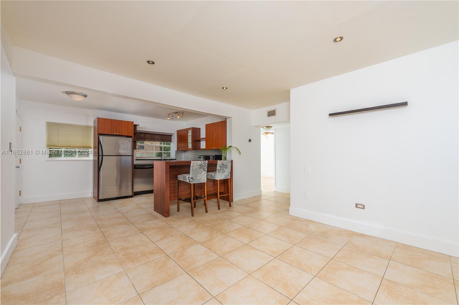 a view of kitchen with furniture and refrigerator