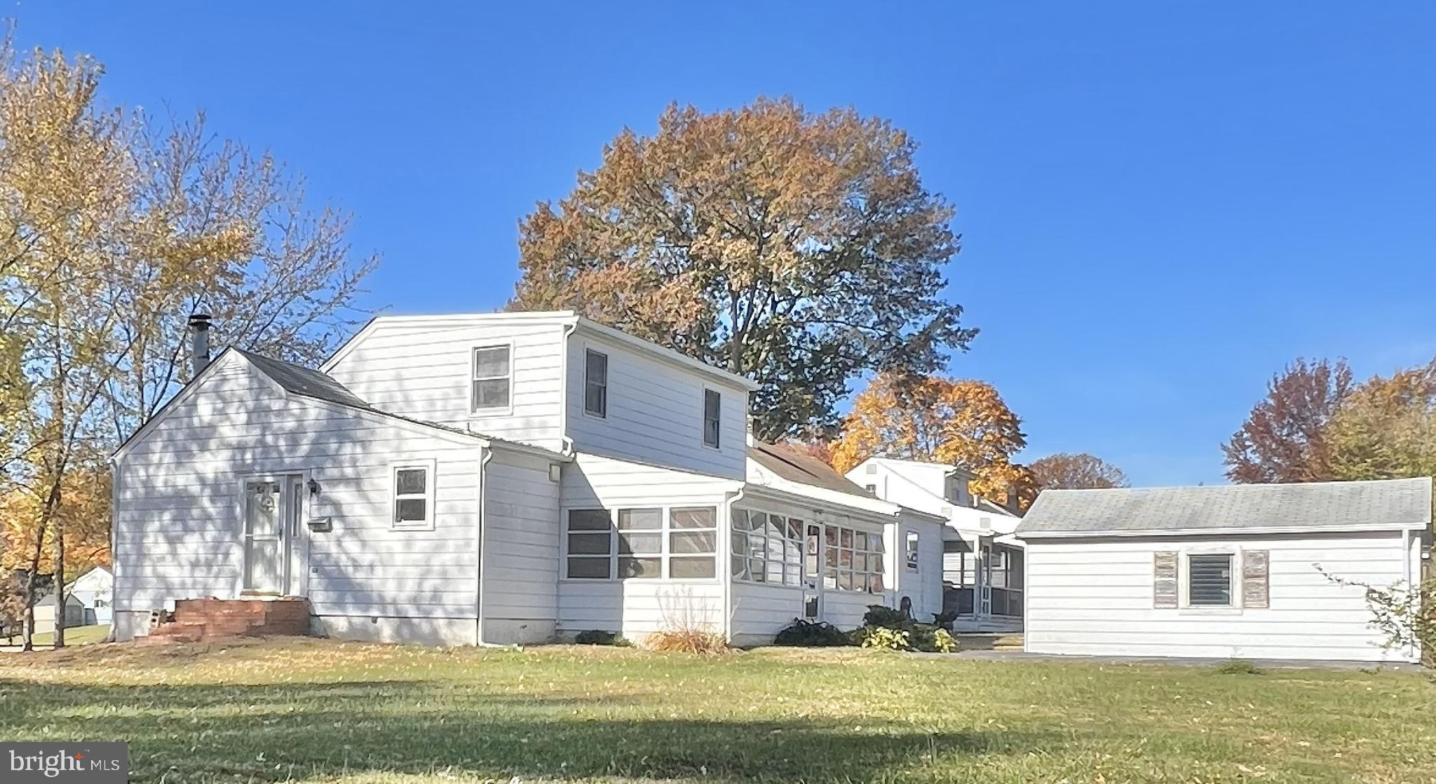 a front view of a house with a garden and tree