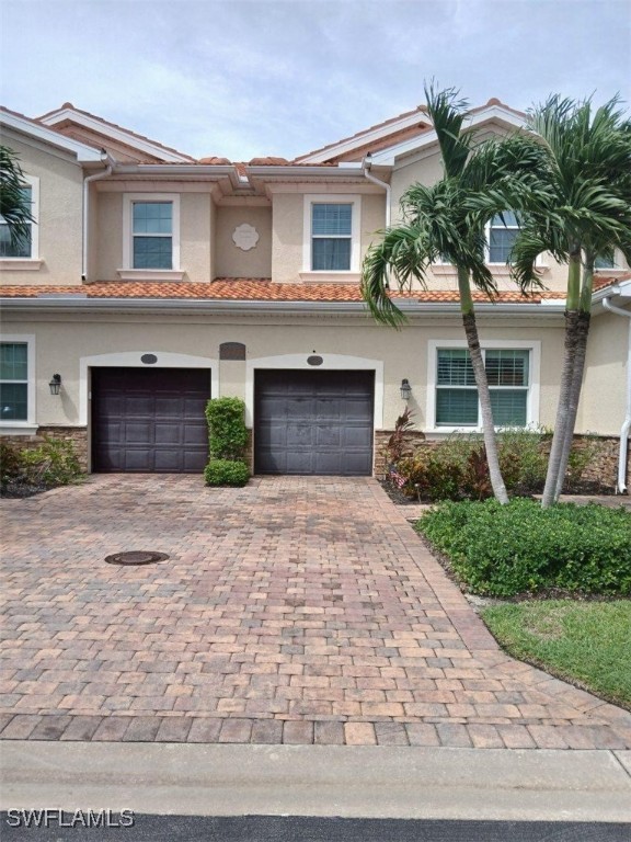 a front view of a house with a yard and a garage