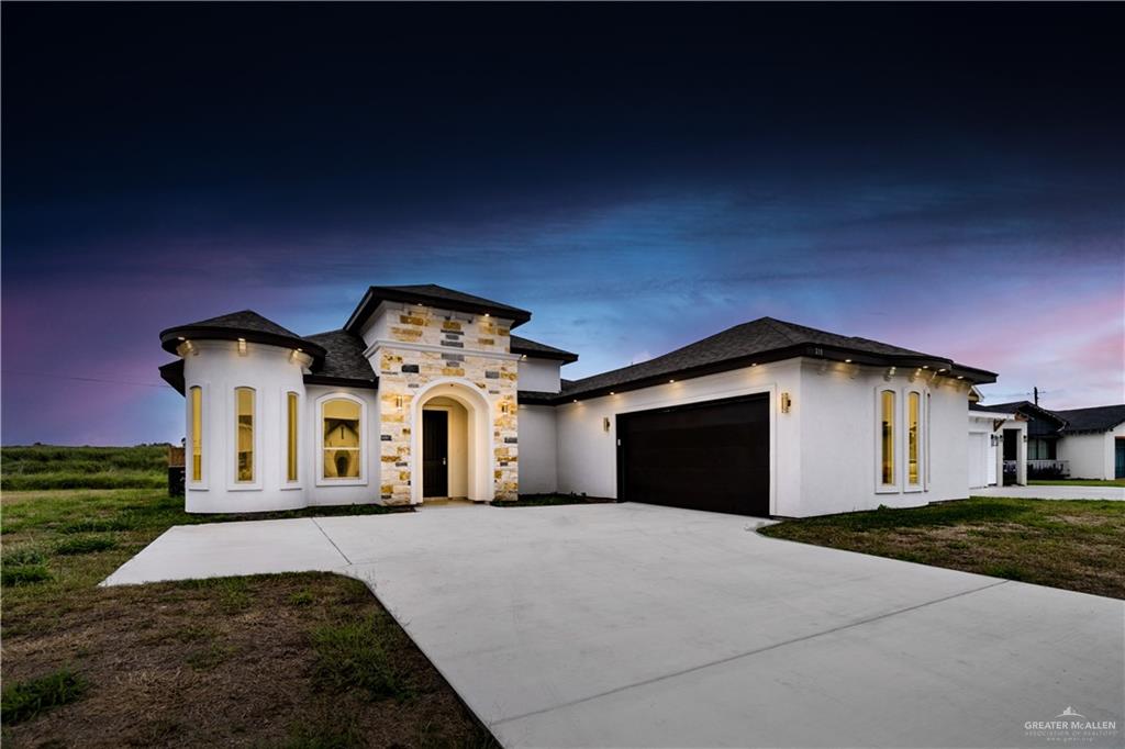 Mediterranean / spanish-style home featuring a yard and a garage