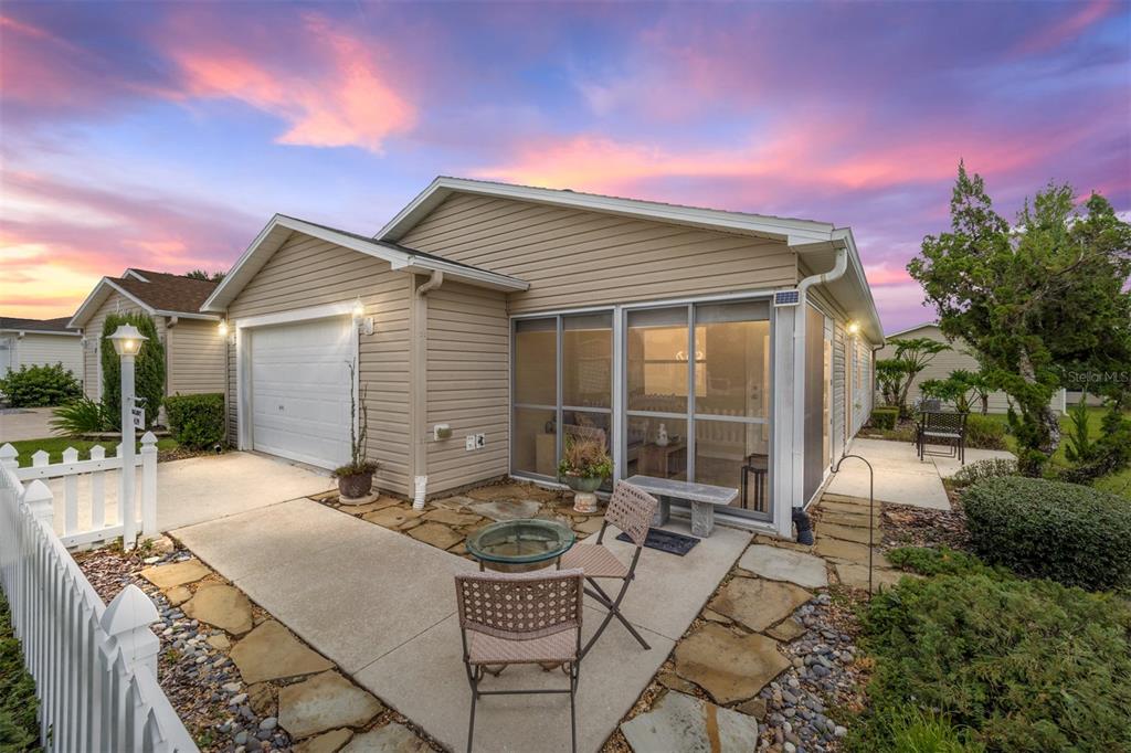 a backyard of a house with table and chairs