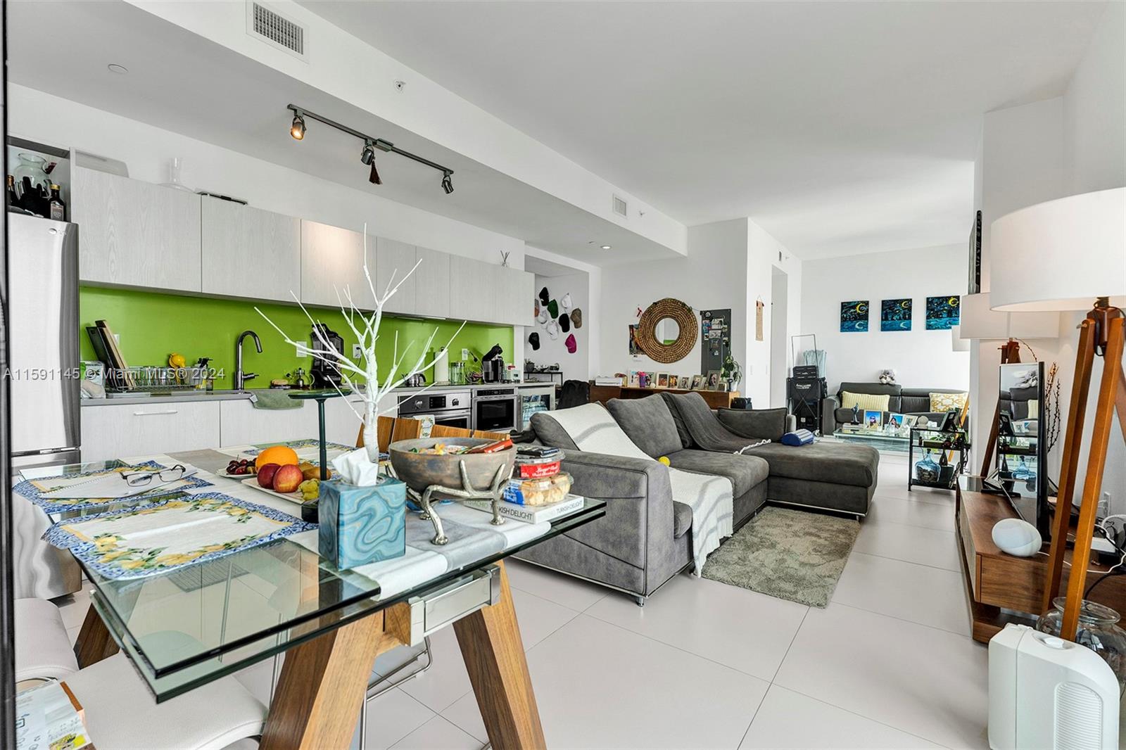 a living room with furniture kitchen view and a large window