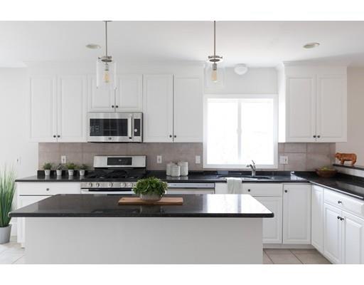 a kitchen with stainless steel appliances kitchen island granite countertop a sink a stove and cabinets