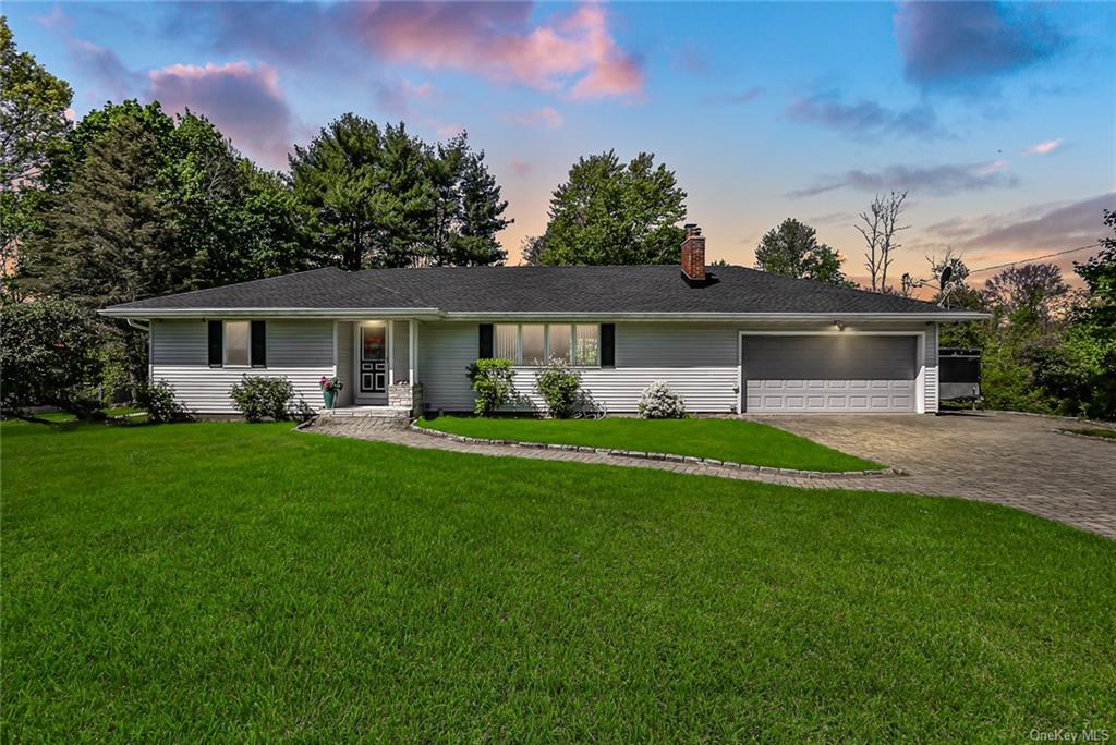 a front view of a house with a yard and green space