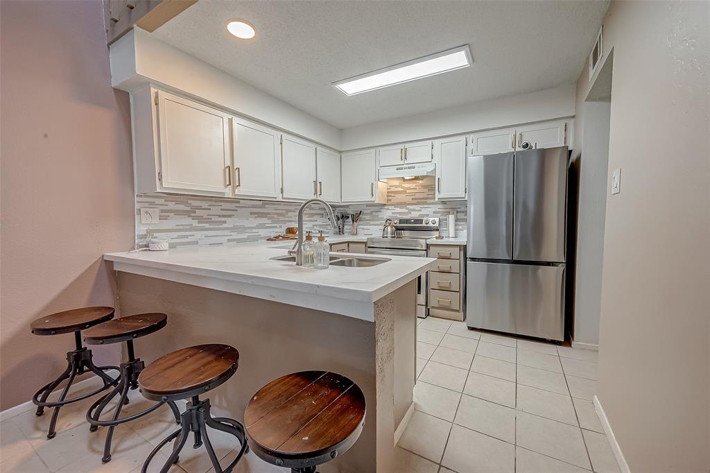 a kitchen with stainless steel appliances a sink cabinets and a refrigerator