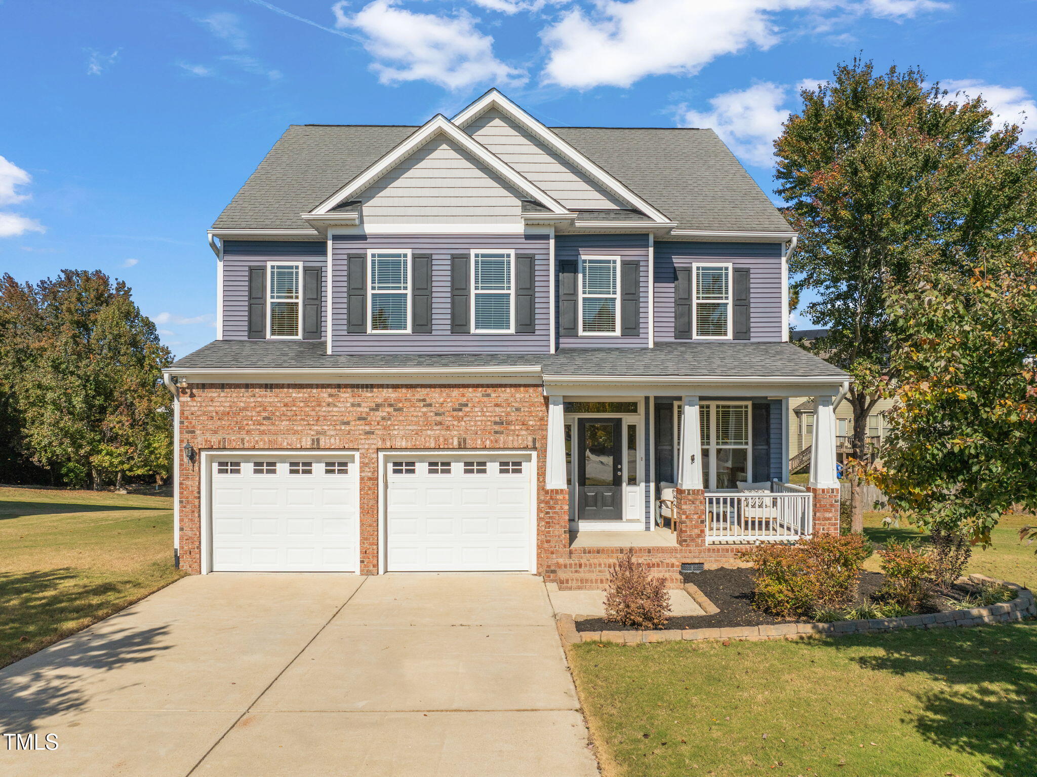 a front view of a house with a yard garage and outdoor seating