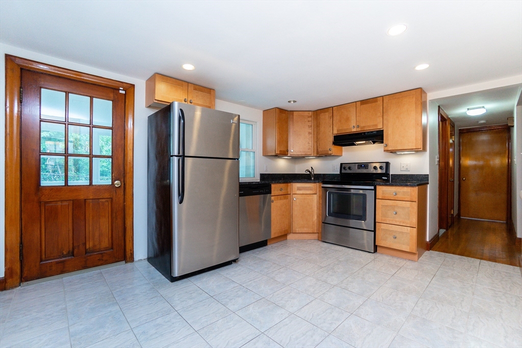 a kitchen with stainless steel appliances granite countertop a refrigerator stove top oven and sink