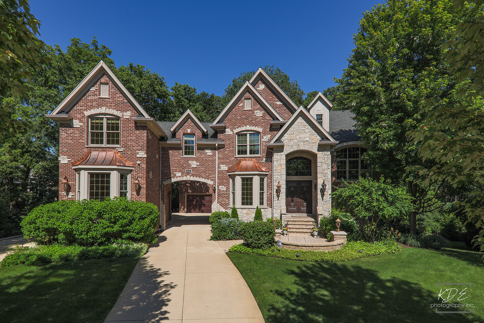 a front view of a house with a yard and trees