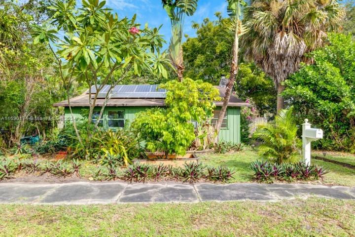 front view of a house with a yard and potted plants