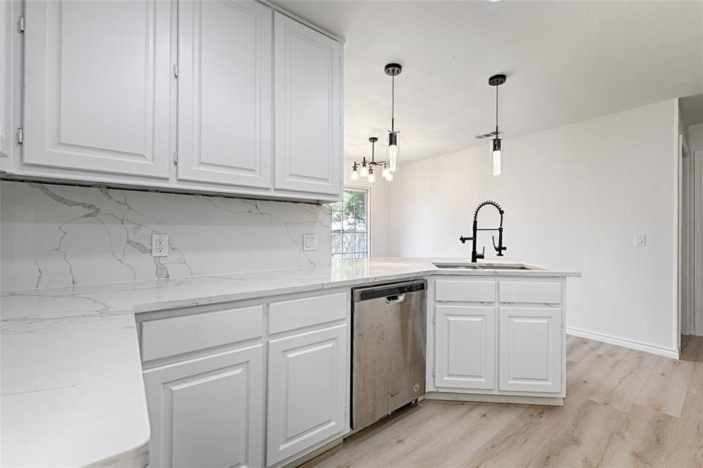 a kitchen with white cabinets and sink