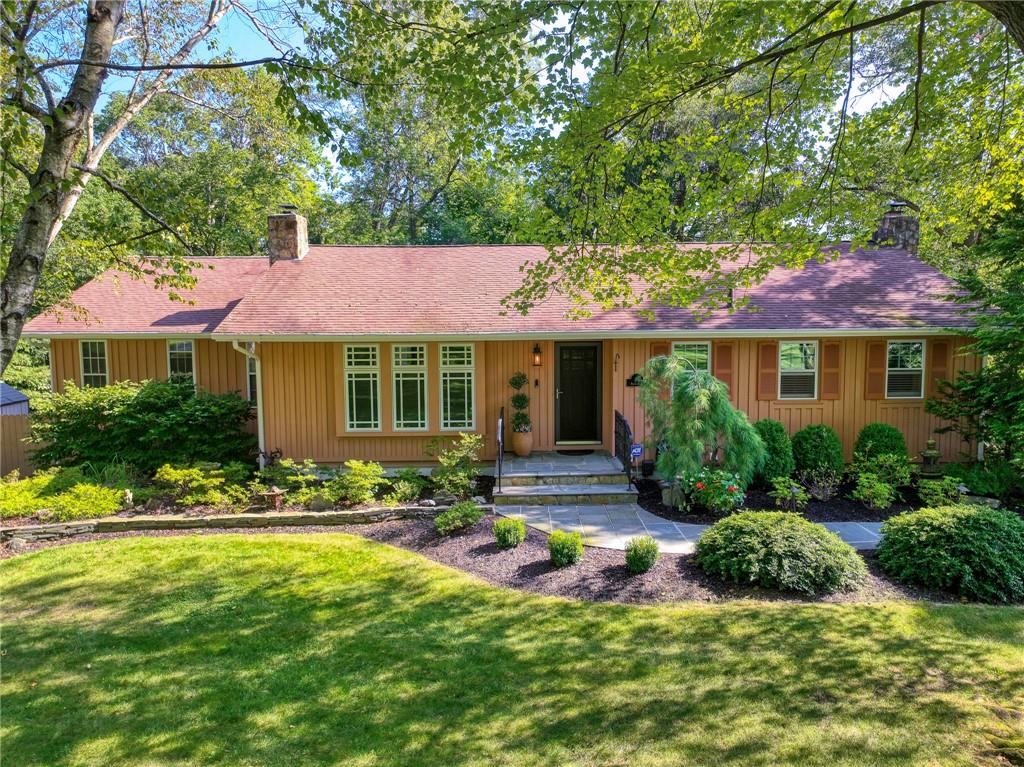 Ranch-style home featuring a front lawn