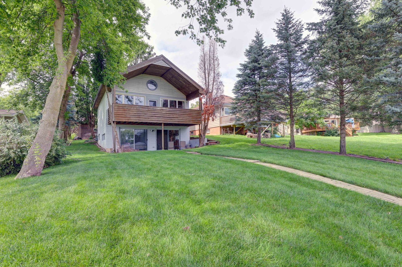 a view of a house with a big yard and large trees