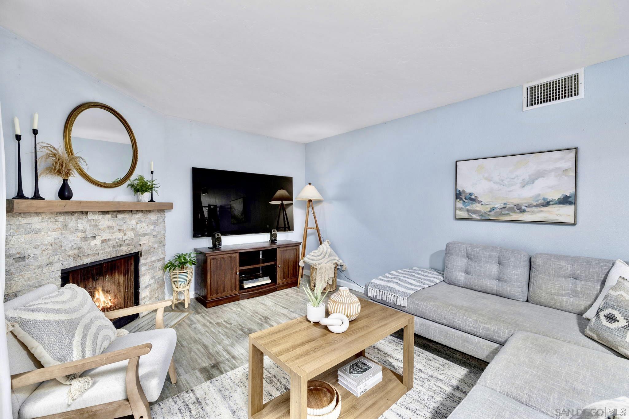 a living room with furniture a flat screen tv and a fireplace