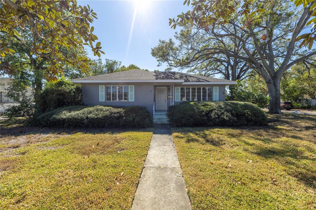 a front view of house with yard and trees around