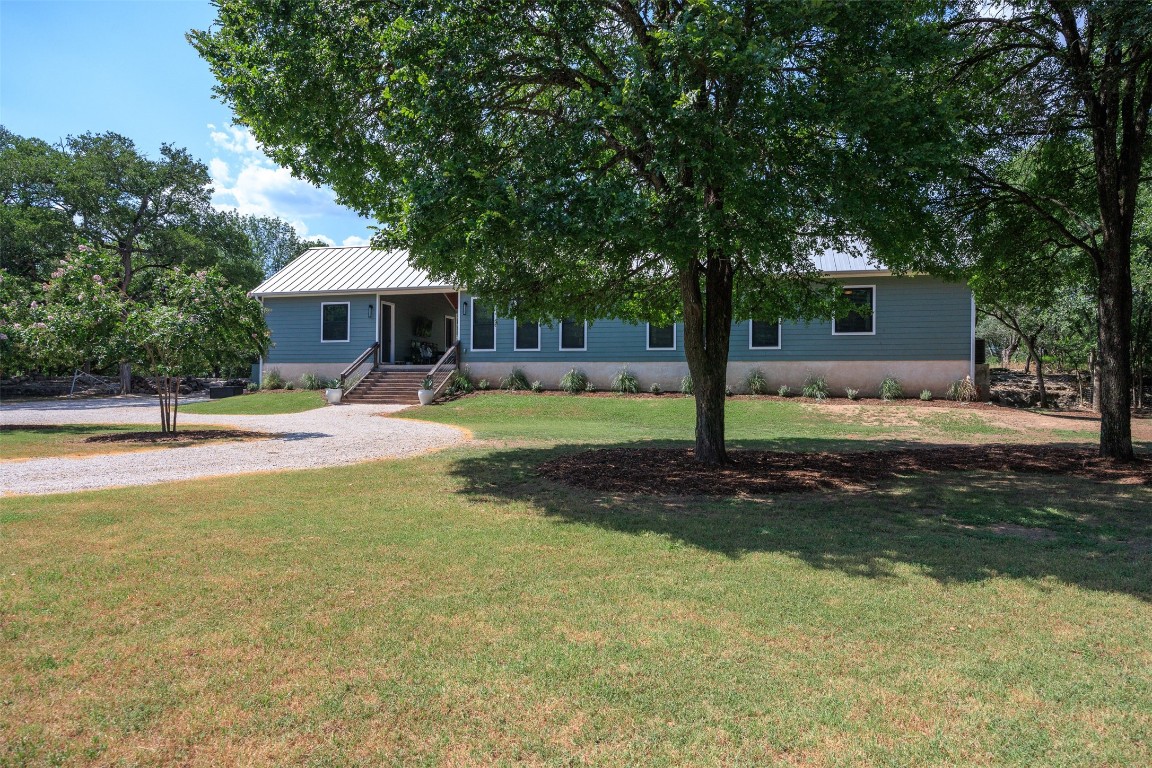 a view of a house with backyard and trees