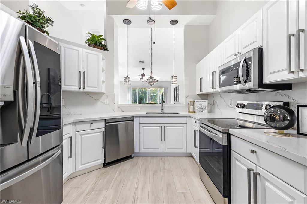 a kitchen with stainless steel appliances granite countertop a stove a sink and a refrigerator