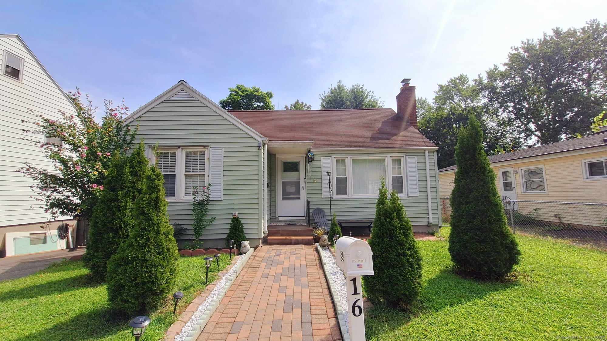 a front view of a house with a yard and trees